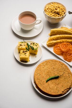 Group of Gujarati snacks like jalebi-fafda, thepla, khaman dhokla, aloo bhujiya, khandvi,khakra, dahi vada, gathiya with hot teaの写真素材