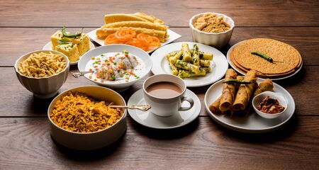 Group of Gujarati snacks like jalebi-fafda, thepla, khaman dhokla, aloo bhujiya, khandvi,khakra, dahi vada, gathiya with hot teaの写真素材