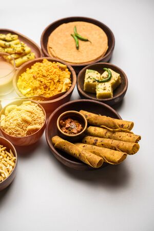 Group of Gujarati snacks like jalebi-fafda, thepla, khaman dhokla, aloo bhujiya, khandvi,khakra, dahi vada, gathiya with hot teaの写真素材