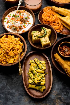 Group of Gujarati snacks like jalebi-fafda, thepla, khaman dhokla, aloo bhujiya, khandvi,khakra, dahi vada, gathiya with hot teaの写真素材