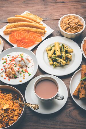 Group of Gujarati snacks like jalebi-fafda, thepla, khaman dhokla, aloo bhujiya, khandvi,khakra, dahi vada, gathiya with hot teaの写真素材