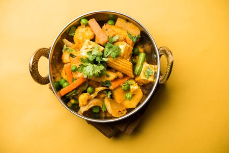 Mix vegetable curry - Indian main course recipe contains Carrots, cauliflower, green peas and beans, baby corn, capsicum and paneer/cottage cheese with traditional masala and curry, selective focusの写真素材