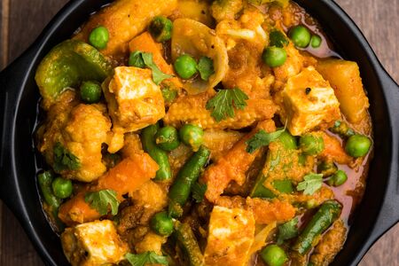 Mix vegetable curry - Indian main course recipe contains Carrots, cauliflower, green peas and beans, baby corn, capsicum and paneer/cottage cheese with traditional masala and curry, selective focusの写真素材
