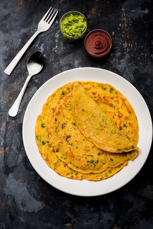 Chilla or Besan cheela is a simple pancake made with chickpea flour and some basic ingredients served with green chutney and tomato sauce, also known as veg-omeletteの写真素材