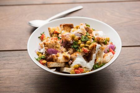 Bread chaat/chat is a yummy starter/appetizer from India, served in a bowl garnished with tomato, sev and coriander and masala. selective focusの写真素材