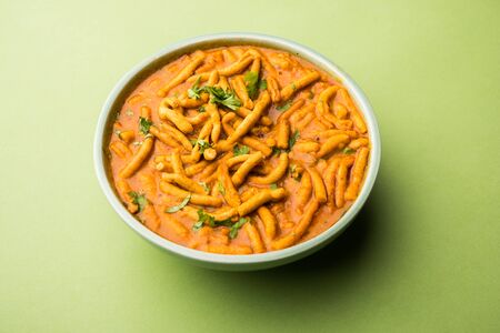 Dhaba style Sev bhaji/sabzi/curry made in tomato curry with gathiya shev, served in a bowl or karahi, selective focusの写真素材
