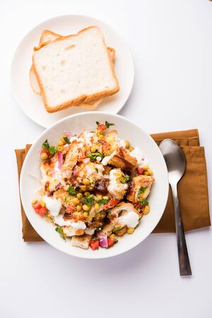 Bread chaat, a yummy starter/appetizer from India, served in a bowl garnished with tomato, sev and coriander and masala. selective focusの写真素材