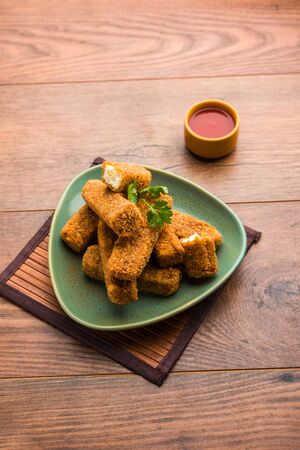 Kurkuri paneer fingers or pakora/pakoda snacks also known as Crispy Cottage Cheese Bars, served with tomato ketchup as a starter. selective focusの写真素材