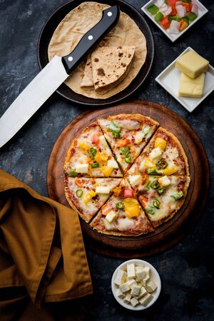 Chapati Pizza made using leftover Roti / Paratha with Cheese, vegetables, paneer and Sausageの写真素材