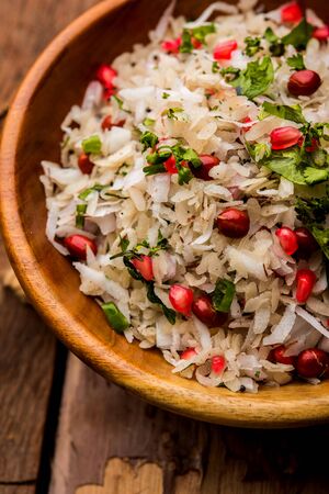 Dapde Pohe is a typical Maharashtrian breakfast, made with thin variety of poha and fresh coconut with chili, peanuts and nuts. served in a bowl or plate.の写真素材