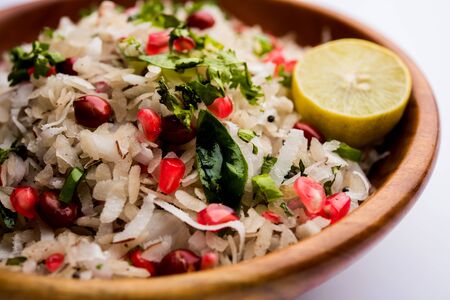Dapde Pohe is a typical Maharashtrian breakfast, made with thin variety of poha and fresh coconut with chili, peanuts and nuts. served in a bowl or plate.の写真素材