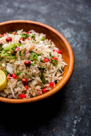 Dapde Pohe is a typical Maharashtrian breakfast, made with thin variety of poha and fresh coconut with chili, peanuts and nuts. served in a bowl or plate.の写真素材