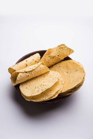 Gujarati papad or papadum in raw dried form with roasted cone, roll and flat variationの写真素材