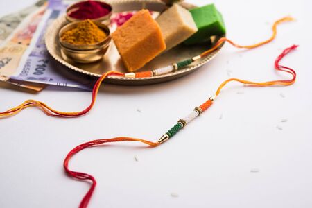 Tricolour Rakhi and Sweets for Independence Day / Raksha Bandhan which is on the Same Day in 2019, puja thali decorated with diya, haldi/kumkum and indian currency as giftの写真素材