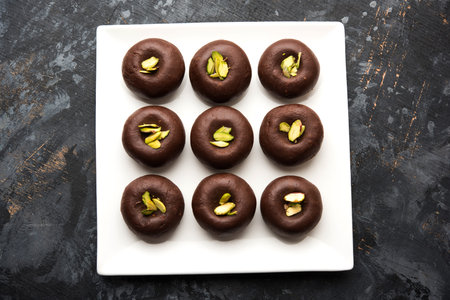 Chocolate Milk peda or pera or pedha made using sweet condensed Milk and cocoa powder, garnished...