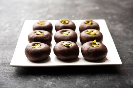 Chocolate Milk peda or pera or pedha made using sweet condensed Milk and cocoa powder, garnished with Pistachio. selective focusの写真素材