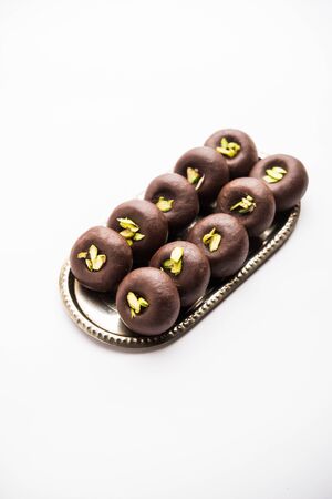 Chocolate Milk peda or pera or pedha made using sweet condensed Milk and cocoa powder, garnished with Pistachio. selective focusの写真素材