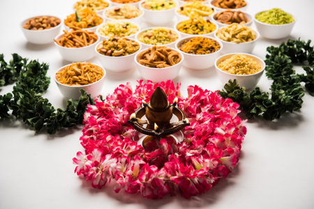 Rangoli of Farsan/snacks in bowls for Diwali with diya