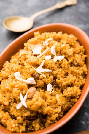 Wheat Laapsi/Lapsi/Shira/Halwa is an Indian sweet dish made of broken wheat or Daliya pieces and ghee along with nuts, raisins and dried fruits. It's a healthy food. served in a bowl, selective focusの写真素材