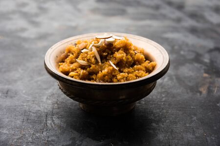 Wheat Laapsi/Lapsi/Shira/Halwa is an Indian sweet dish made of broken wheat or Daliya pieces and ghee along with nuts, raisins and dried fruits. It's a healthy food. served in a bowl, selective focusの写真素材