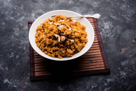 Wheat Laapsi/Lapsi/Shira/Halwa is an Indian sweet dish made of broken wheat or Daliya pieces and ghee along with nuts, raisins and dried fruits. It's a healthy food. served in a bowl, selective focusの写真素材