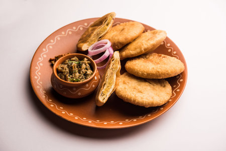 Fried Sattu Litti chokha served with Baingan Bharta, onion and pickle, popular recipe from Bihar,...