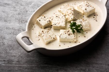 Paneer Dum Kali Mirch / Kalimirch, prepared in a white creamy gravy and black pepper powder sprinkled over it. served in a bowl. Selective focusの写真素材