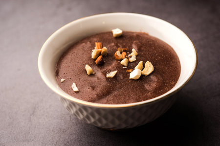 Sweet Ragi Malt / Healthy Ragi Porridge in a bowl garnished with crushed dry fruitsの写真素材