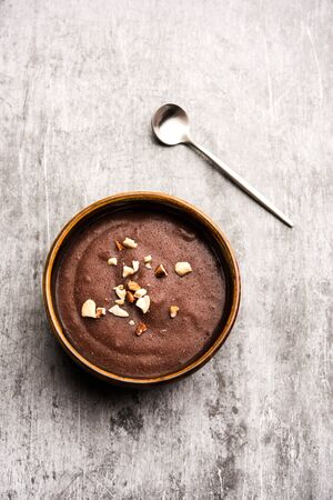 Sweet Ragi Malt / Healthy Ragi Porridge in a bowl garnished with crushed dry fruitsの写真素材