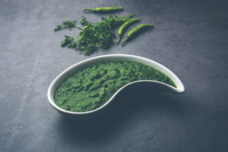 Kothimbir or Dhaniya Chutney made using cilantro or coriander with chilli, served in a bowl.
