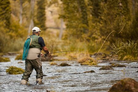 Man fishing for trout and salmon in a riverの写真素材
