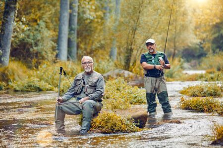 Men in river fishing posing for a portraitの写真素材
