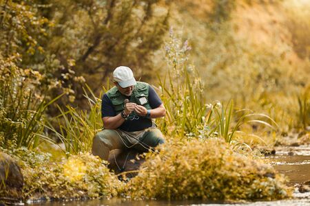 Man fishing for trout and salmon in a riverの写真素材