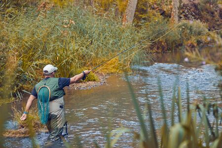 Man fishing for trout and salmon in a riverの写真素材