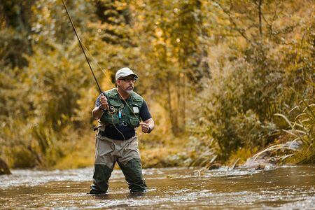 Man fishing for trout and salmon in a riverの写真素材