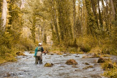 Man fishing for trout and salmon in a riverの写真素材