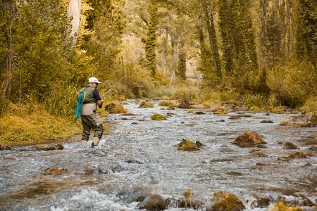 Man fishing for trout and salmon in a riverの写真素材