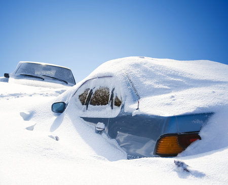 cars covered with snow in the winter blizzard
