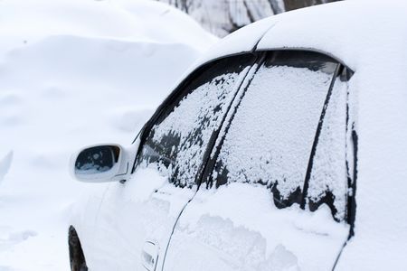 cars covered with snow in the winter blizzardの写真素材