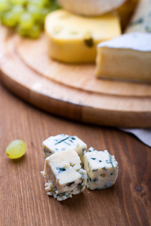 big group of cheeses with white grapes