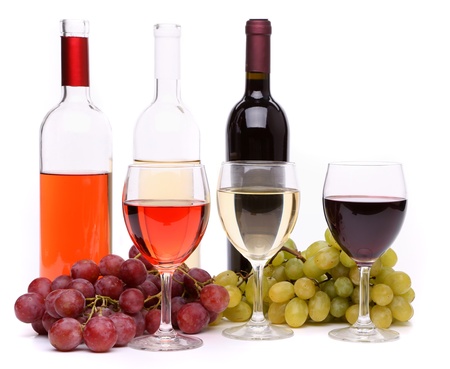 Ripe grapes, wine glasses and bottles of wine isolated on whiteの写真素材
