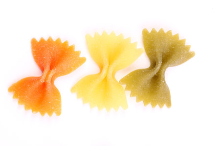Close-up pasta farfalle three colors are located on the white background.の写真素材