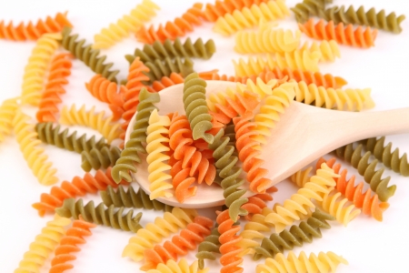 A pasta eliche tricolori and a wood spoon.の写真素材