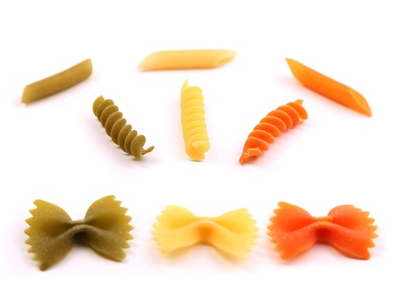 A composition of different pasta in three colors on the white background.の写真素材