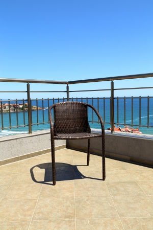 Lonely armchair against the sea rolling in the skyの写真素材