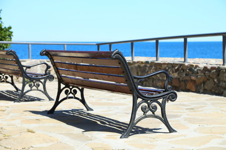 Wrought-iron bench on a stone seafront  Background 