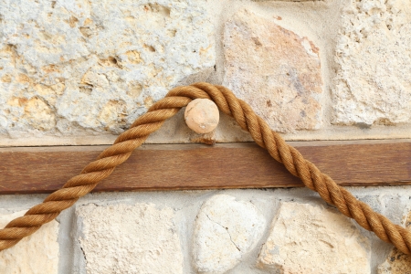 Rope on the background of an old stone wallの写真素材