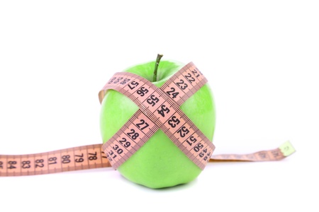 Green apple with measuring tape. White background.の写真素材