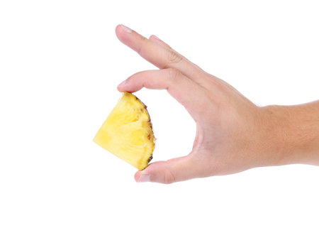 piece of pineapple in hand on a white background