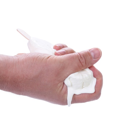 Hand presses vanilla ice cream on stick. White background.の写真素材